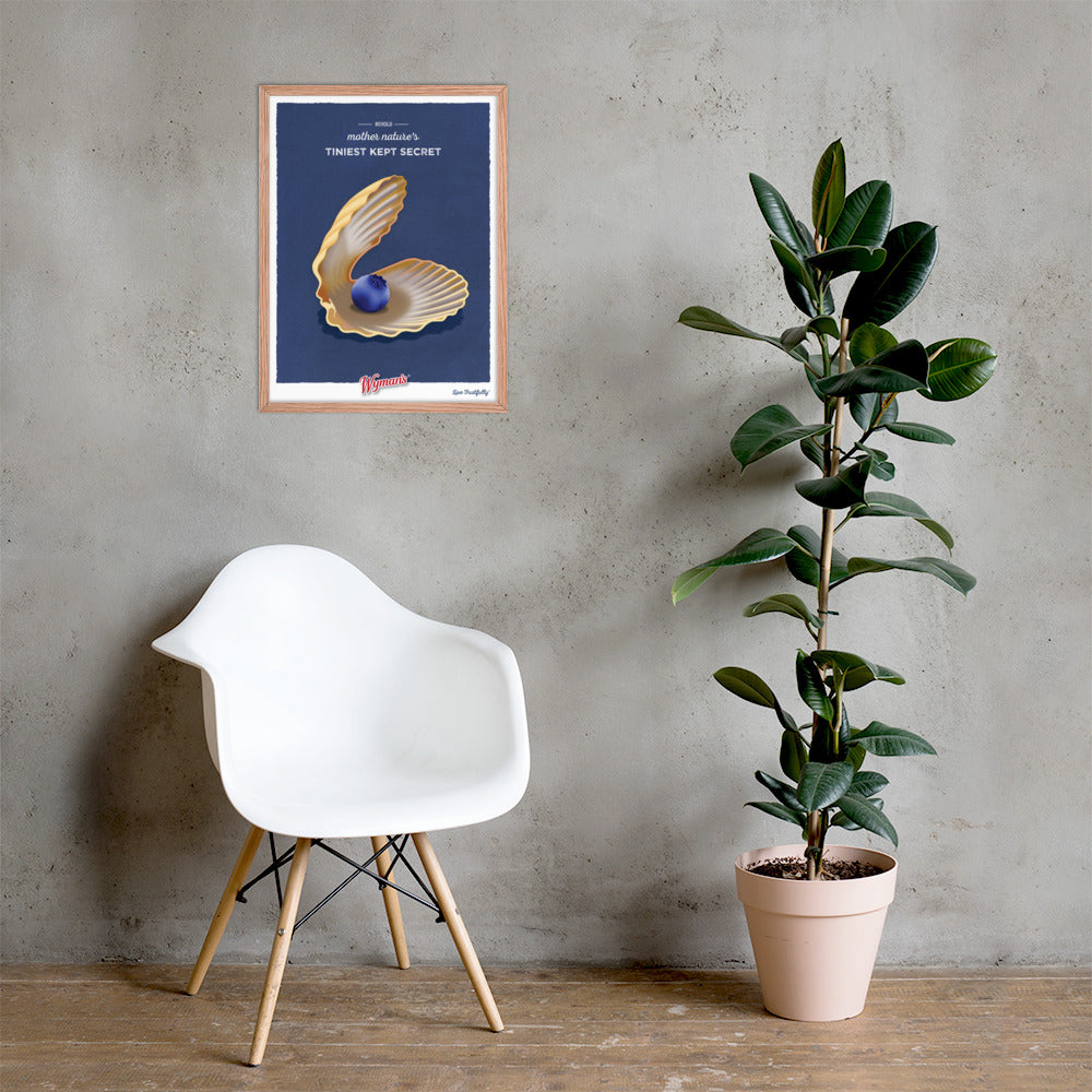 A framed Behold Mother Nature's Tiniest Kept Secret Poster by Shop Wyman's with an oyster and a blueberry on it next to a chair.