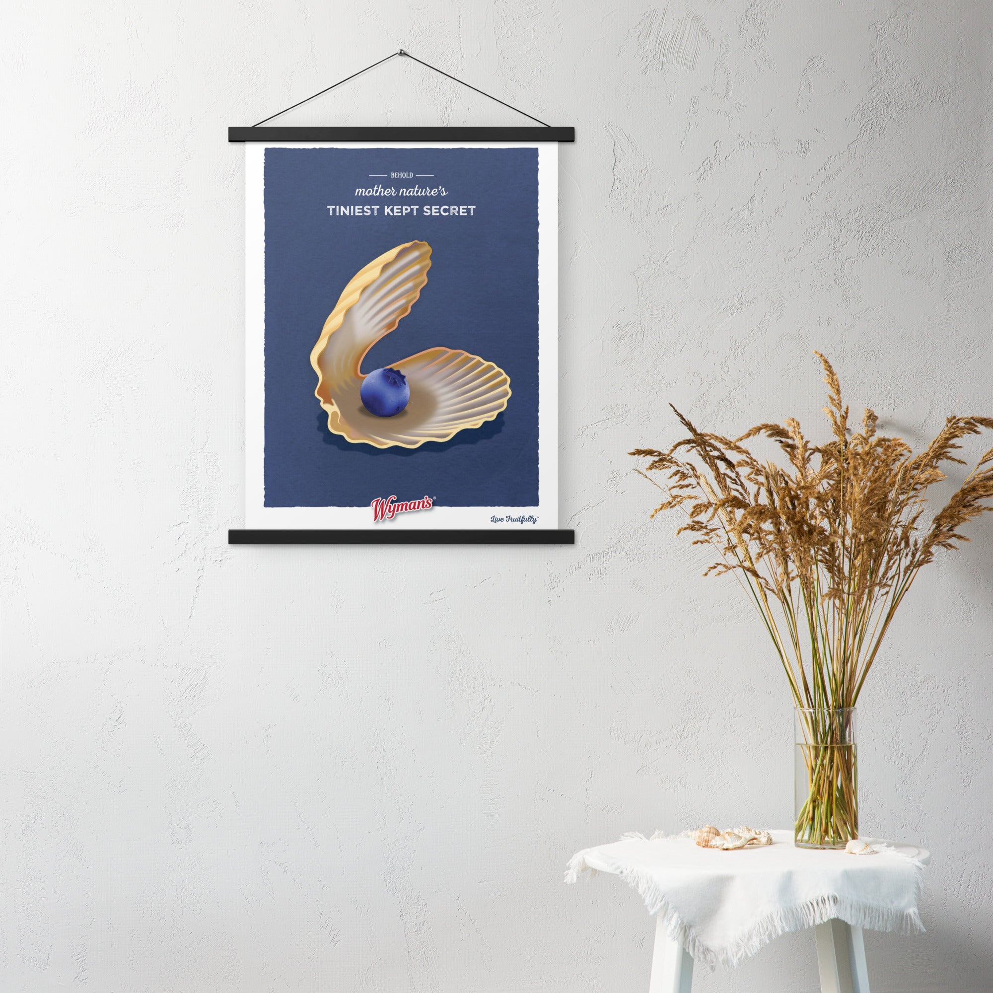 A Behold Mother Nature's Tiniest Kept Secret poster, designed with blueberry hues, hanging on a wall from Shop Wyman's.