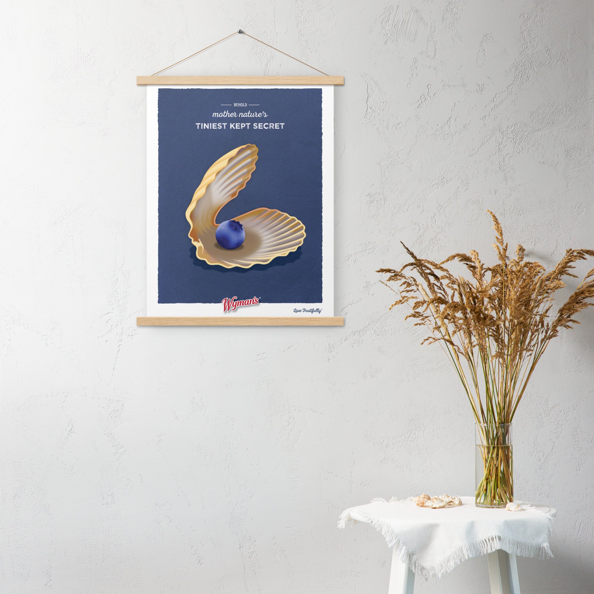 A Behold Mother Nature's Tiniest Kept Secret poster with an image of a shell hanging on a wall from Shop Wyman's.