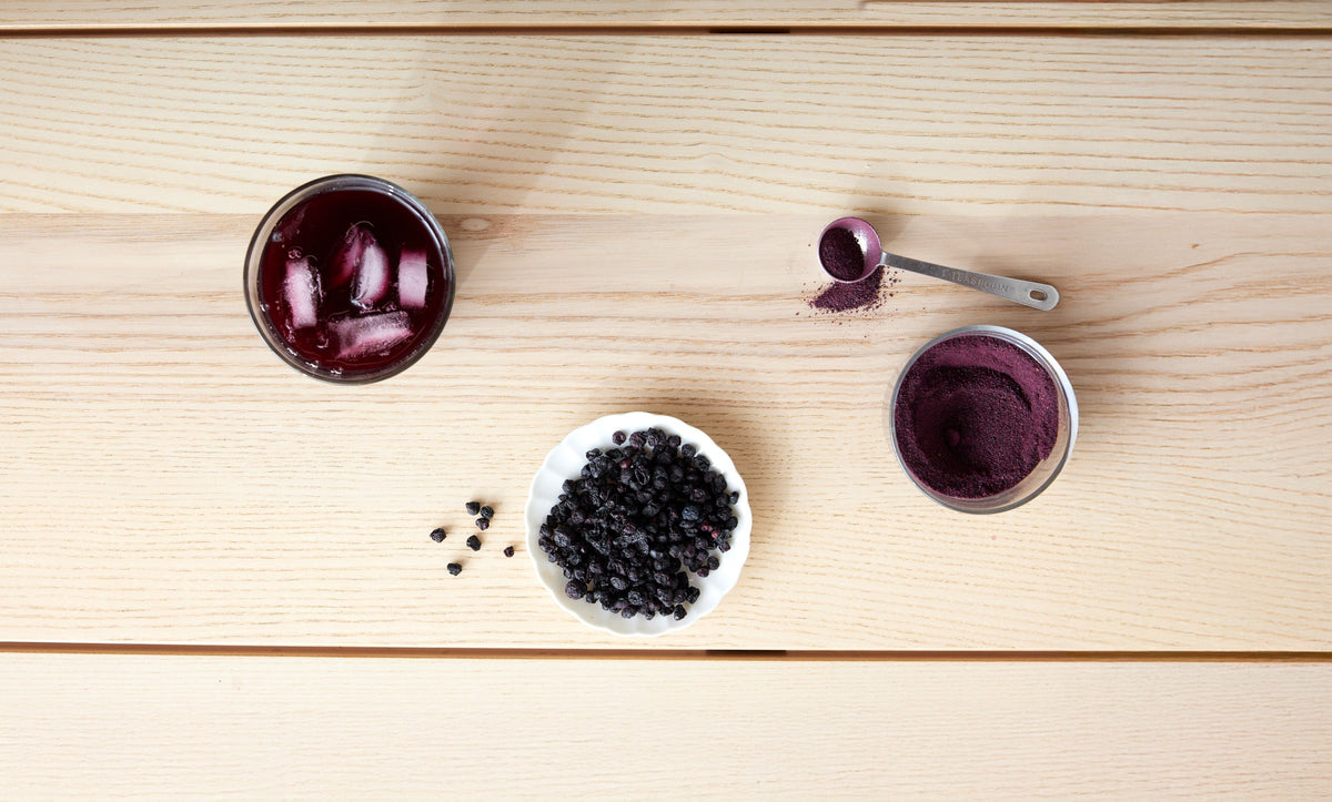 wild blueberry juice, wild blueberry powder and dried wild blueberries on wood background