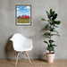 A framed From Our Fields to Your Family Poster of a red truck on a wall next to a chair.