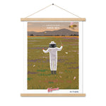 A Shop Wyman's In Concert with Nature Since 1874 Poster with a custom display of a man in a bee suit flying in a field, featuring premium printing finishes.