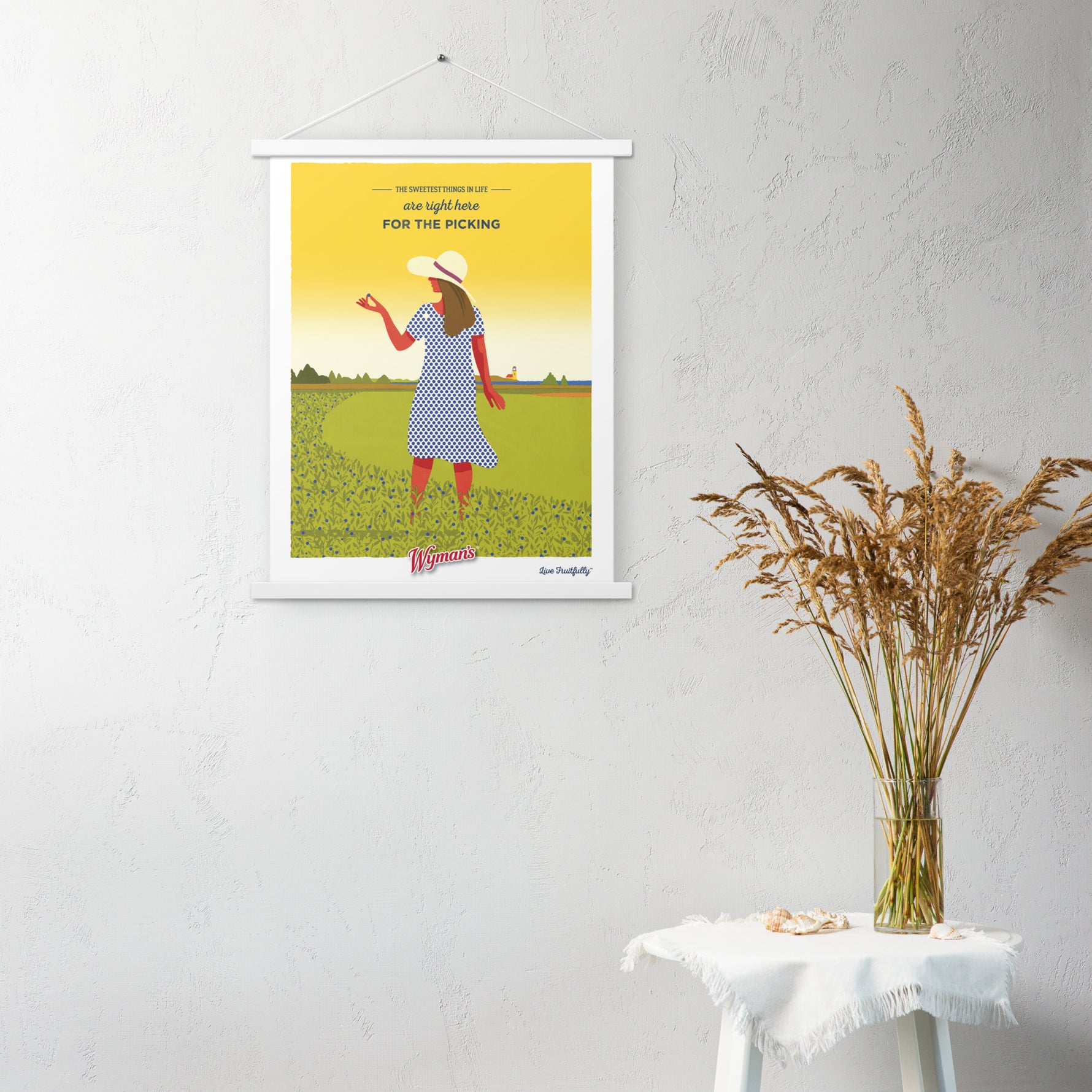 A Shop Wyman's custom poster hanging on a wall with a woman in a field.
