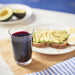 A glass of Whitney 100% Wild Blueberry Juice with toast and avocado on a cutting board.