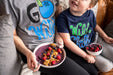 A woman and a child sitting on a couch eating a bowl of Wyman's wild blueberries.