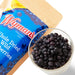 Woman's Whitney whole dried Wild Blueberry snack in a glass next to a bag.